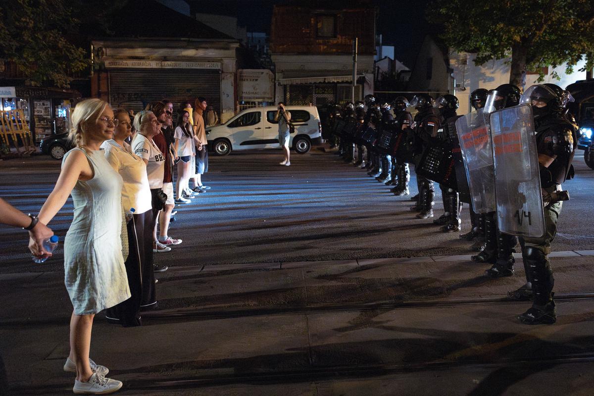 Građani stoje naspram policijskog kordona na noćnom protestu